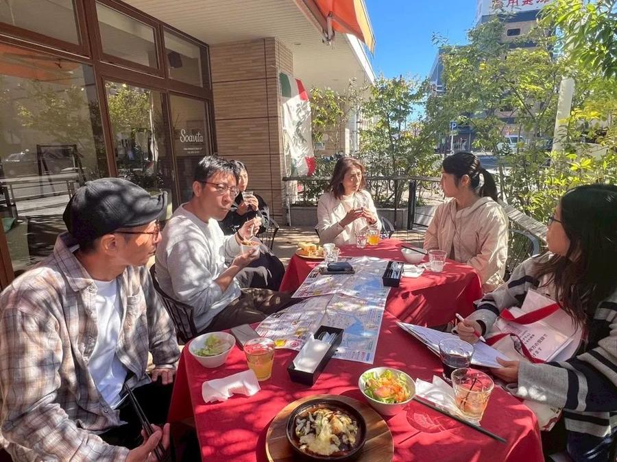 テラスで料理を囲んで話す人たち